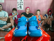Front view of blue Nike basketball sneakers showing the laces, textured toe panels, red accents, and patterned outsole.