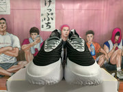 Front view of the black-and-white sneakers showing the rounded toe areas, patterned laces, and visible “30” markings on the lace panels.