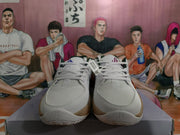 Front view of white basketball sneakers showing textured toe panels, laces, and speckled tan midsoles.