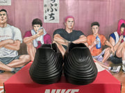 Rear view of black slip-on clogs showing the sculpted heels and ridged sides.