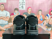 Rear view of the black sneakers showing padded collars, heel panels, visible number 34, and textured rubber outsoles.