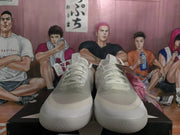 Front view of the white sneakers showing the rounded toe, tonal laces, textured upper, and thick rubber outsole.