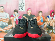 Front view showing the black lace-up uppers and red toe outsoles.