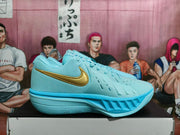 Side profile of a blue Nike basketball shoe showing gold-tone Swoosh detailing and a sculpted outsole.