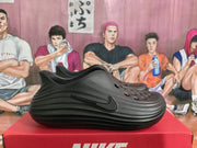 Side view of a black perforated clog showing the Swoosh and ridged profile.