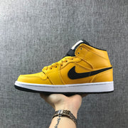 Side profile of the yellow mid-top sneaker with black branding and a white midsole.