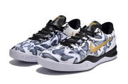 Pair of Kobe 8 sneakers with a gray, black, and white camouflage-style upper and gold swoosh.