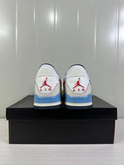Rear view of the white, blue and red Jordan Legacy 312 Low sneakers on a black box.