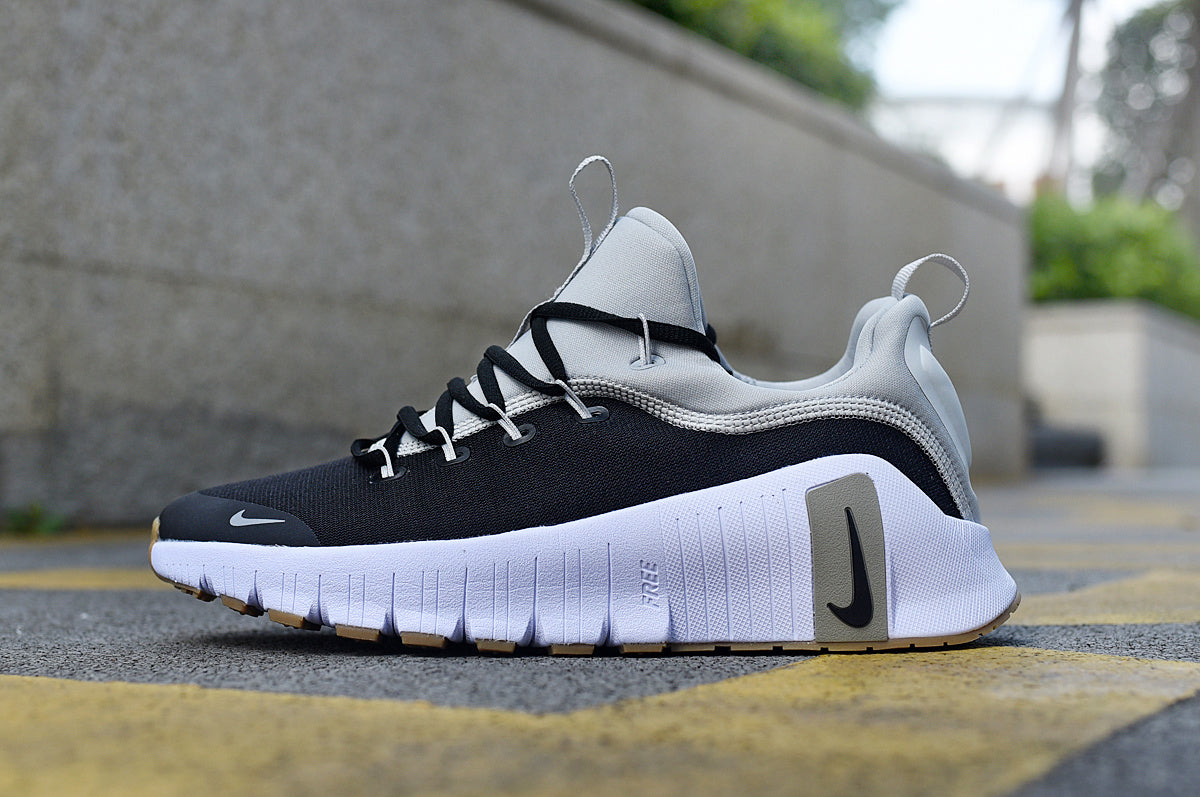 Black and grey Nike lace-up training shoe with a white sole and gum-colored outsole details.
