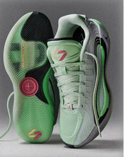Top and outsole view of pale green basketball sneakers showing Luka branding, black traction sections, and a translucent herringbone-pattern outsole.