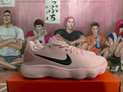 Side profile of a pink Nike low-top sneaker with a black Swoosh and textured sole.