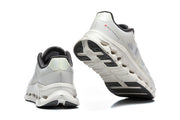 Rear and outsole views of the white and gray On Cloudtilt Remix sneakers.