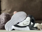 Side view with one sneaker turned to display the textured outsole pattern.