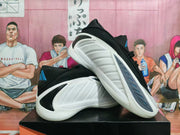 Pair of white, black, and blue basketball shoes displayed at an angle.