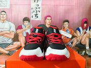 Front view of black and red Nike sneakers showing white toe panels, red laces, and red outsole edges.