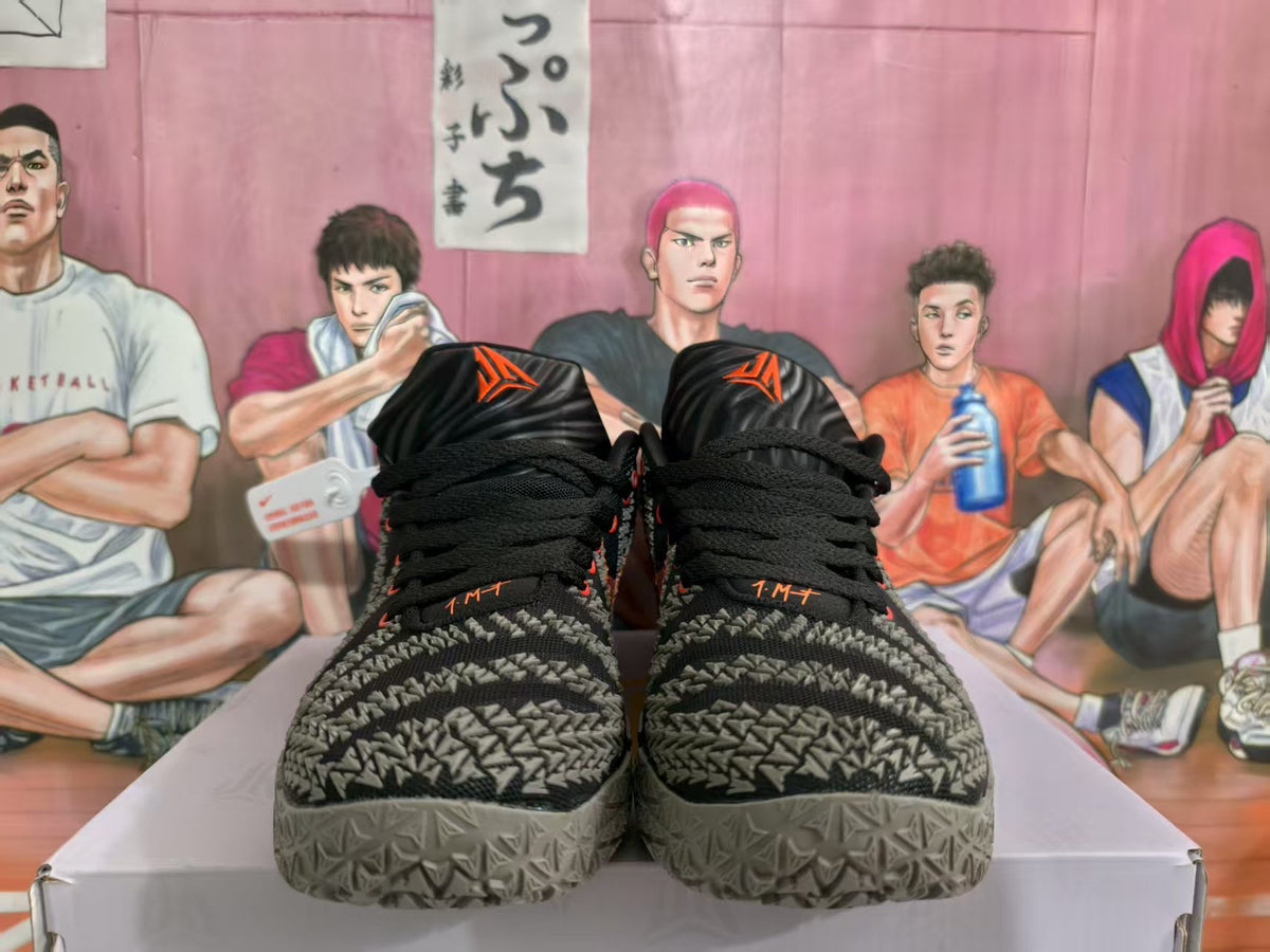 Front view of black, grey, and red Nike basketball shoes with a patterned upper and grey outsole