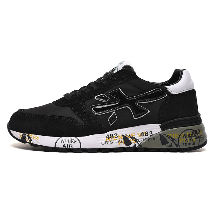Side view of a black low-top sneaker with a large outlined side emblem, white heel accent, and printed graphics on the midsole.