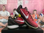 Angled view of the black and red Nike Zoom basketball sneakers displayed together, showing the textured upper and translucent outsole.