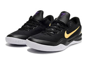 Pair of black Kobe 8 sneakers with a gold swoosh and white midsoles.