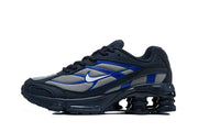 Side profile of a navy, silver-gray, and blue Nike Shox Ride 2 sneaker.