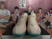 Front view of the pair showing cream perforated toe boxes, pink overlays, laces, and teal outsoles.