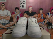 Front view of white Nike low-top sneakers showing white laces, perforated toe boxes, and a textured outsole.