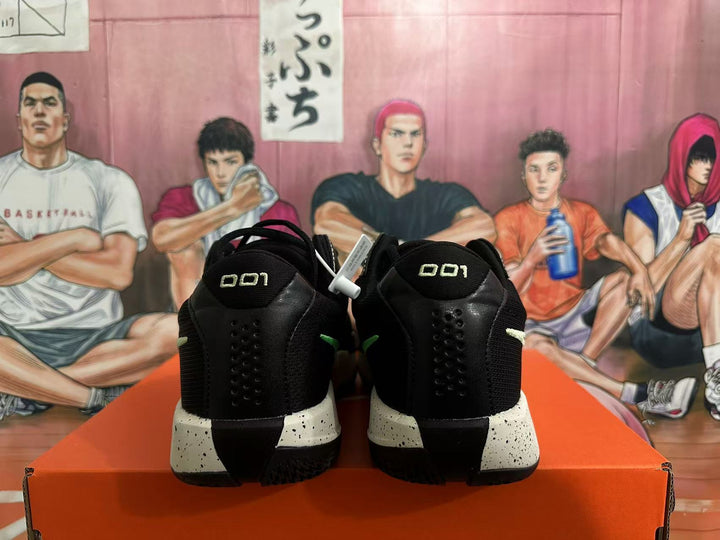 Rear view of black Nike basketball shoes with green accents and speckled midsoles.