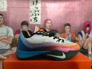 Side view of a Nike basketball shoe with a white upper, multicolor gradient panels, black outsole and white Swoosh.