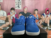 Front view of blue lace-up basketball shoes with white outsoles and tongue logos.