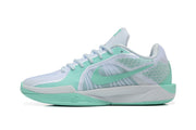 Side profile of a white and mint-green Nike Sabrina basketball shoe
