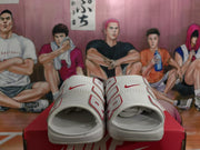 Top-front view showing the perforated white uppers, red Nike logos, and open-toe design.