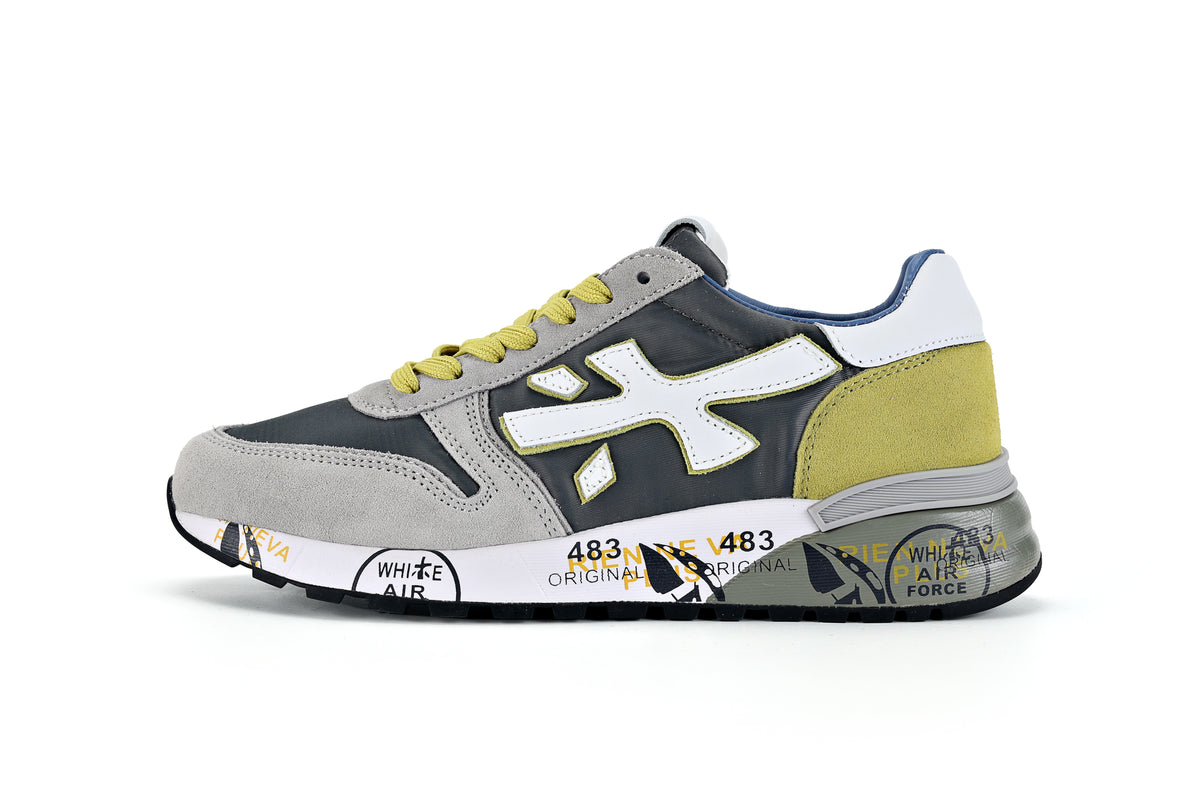 Side view of a gray, charcoal, white and yellow-green Premiata low-top sneaker with lace-up fastening and printed midsole.