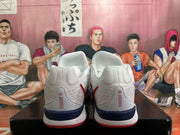 Rear view of white Nike basketball shoes with navy heel details and red outsole accents.