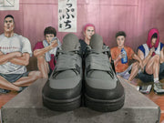Pair of gray and black high-top sneakers viewed from the front, showing the laces, textured side sections, and dark toe overlays.