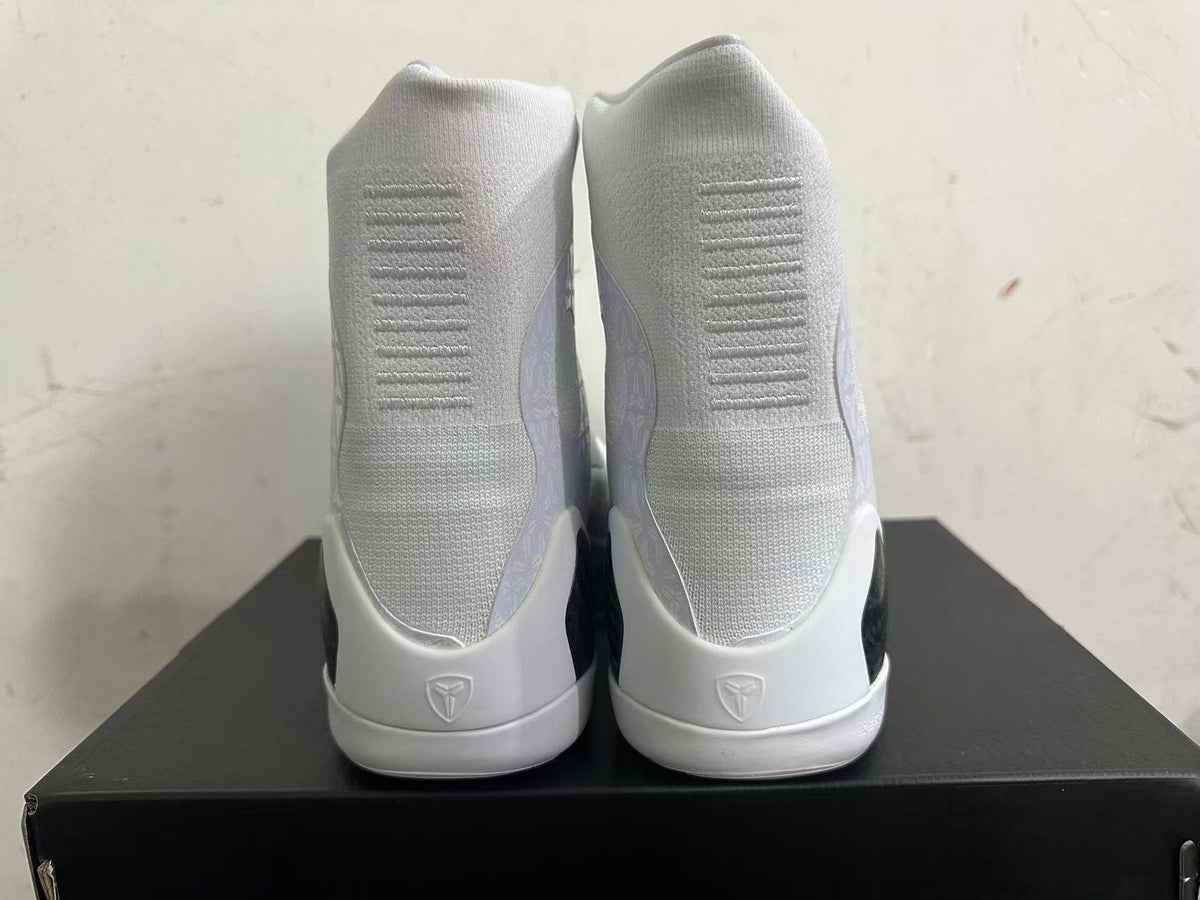 Rear view of white high-top basketball shoes with ribbed heel details and Kobe emblems.