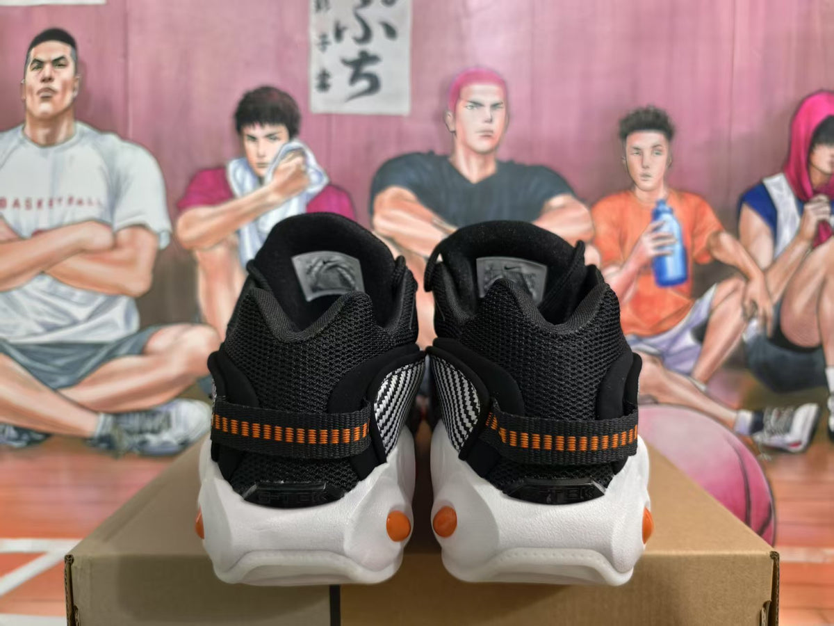 Rear view of black Nike sneakers with orange-and-black heel details and white outsoles.