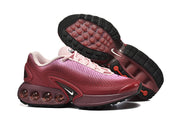 Side view and outsole of pink gradient Nike Air Max DN sneakers.