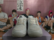 Front view of the white speckled sneakers showing the laces, perforated toe areas, and tongue emblems.