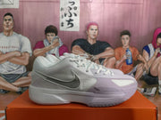 Side view of a white and pale purple Nike basketball sneaker displayed on an orange shoebox.