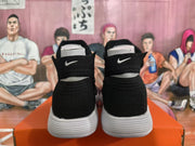 Rear view of black high-top Nike sneakers showing small white Swoosh logos and white ridged soles.
