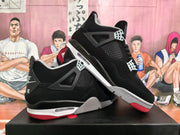 Angled product view showing both black sneakers, grey midsole accents, mesh panels, and red outsole sections.