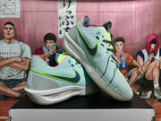 Angled view of a pair of light blue, green, pink, gray, and navy Nike basketball sneakers displayed together.