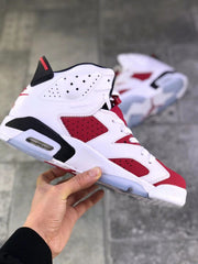 Side profile showing the red perforated panels, white overlays, black accents, and visible heel cushioning window.