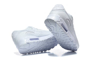 White Nike Air Max 90 sneakers shown from the heel and outsole.
