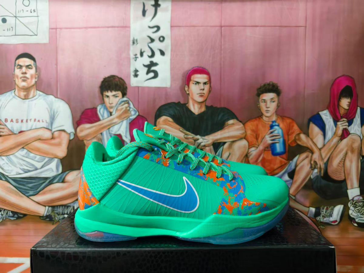 Side view of green Nike basketball shoes with blue and orange graphics and a contrasting Swoosh.