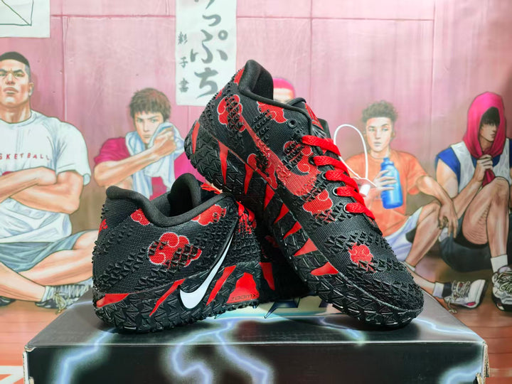 Pair of black and red Nike basketball sneakers displayed on a box, showing the outer sides and textured uppers.
