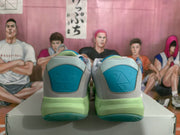 Rear view showing the blue heel panels, green midsoles, and teal outsoles.