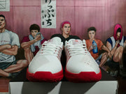 Front view showing the white uppers and red soles of the basketball shoes.