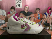 Side profile of a white low-top sneaker with purple and lime-green Converse-style branding details.