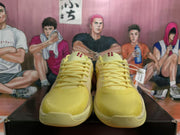 Front view of yellow Nike sneakers with tonal laces, textured toe boxes, and visible 20 markings.